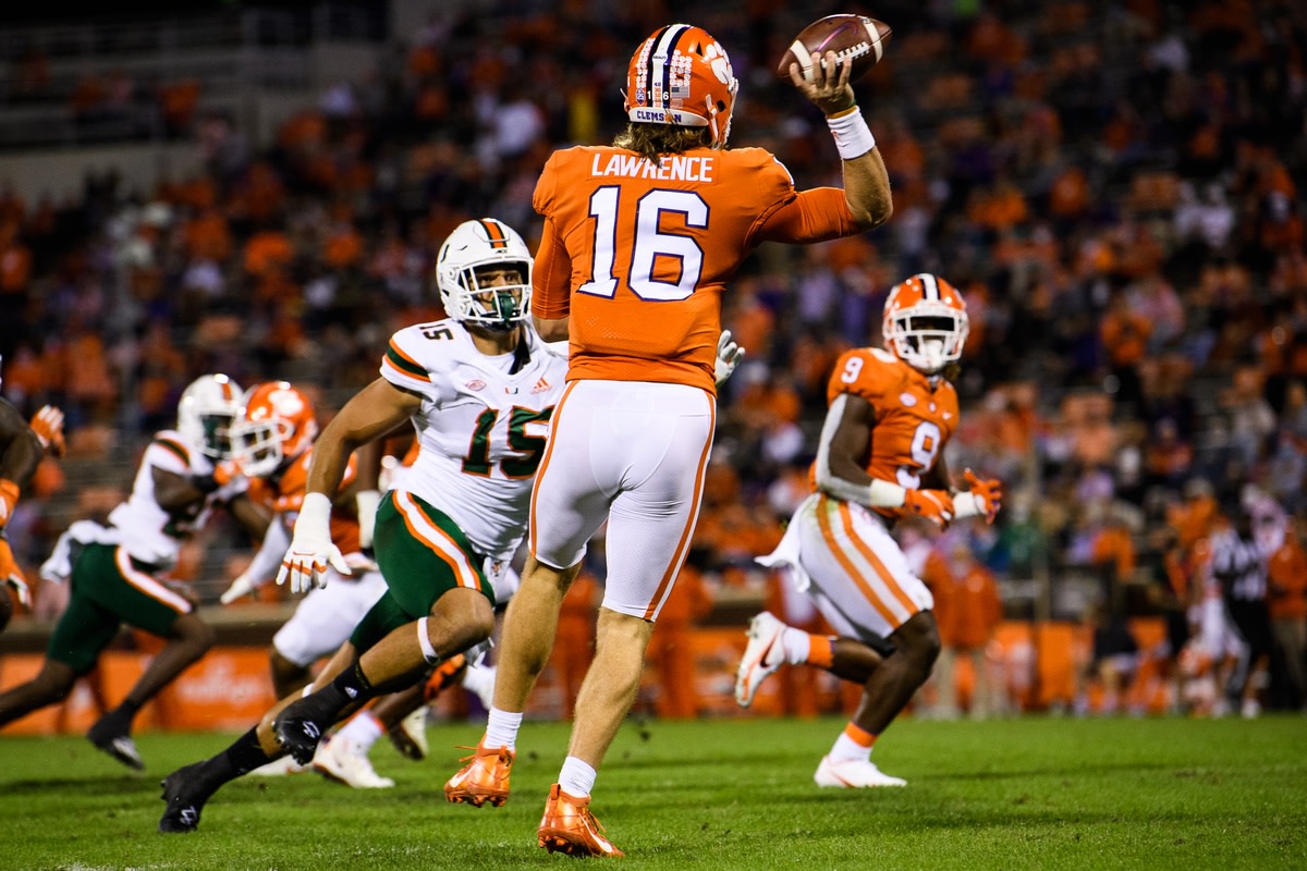 Oct 10, 2020; Clemson, South Carolina, USA; Clemson Tigers quarterback Trevor Lawrence (16) throws to running back Travis Etienne (9) against Miami Hurricanes defensive line Jaelan Phillips (15) during the first quarte at Memorial Stadium. Mandatory Credit: Ken Ruinard-USA TODAY Sports